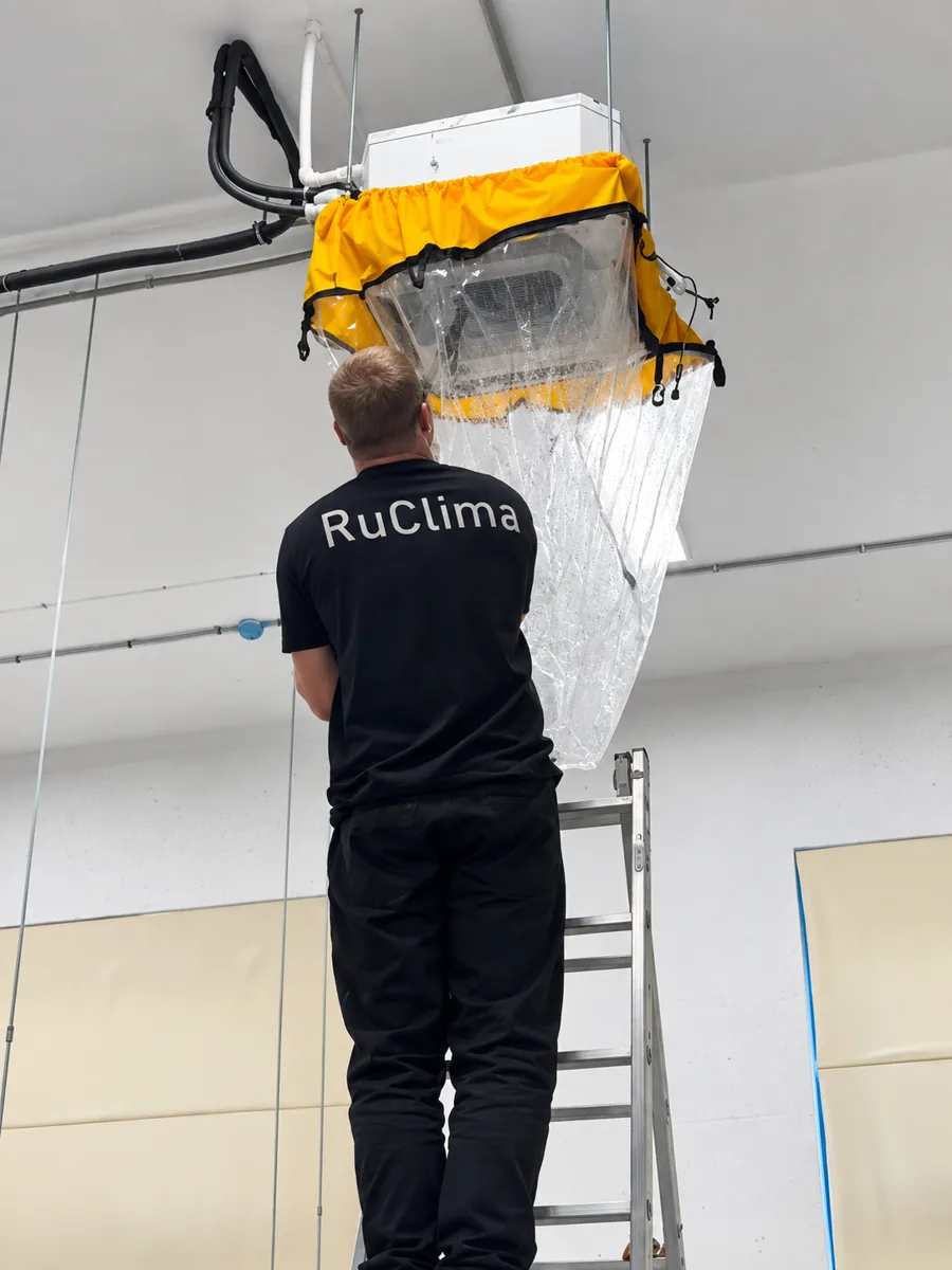 Мастер RuClima обслуживает кондиционер с сервисным чехлом