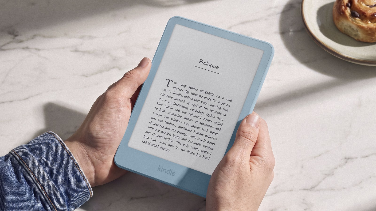 Amazon Kindle 2026 в руках за чтением — официальное фото Amazon