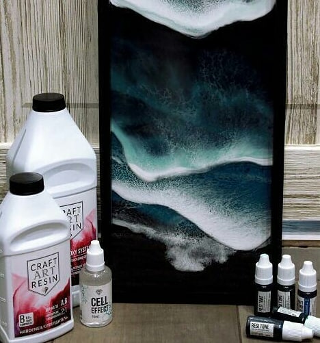 Картина из смолы с морской волной рядом с канистрами Craft Art Resin и флаконом добавки Cell Effect
