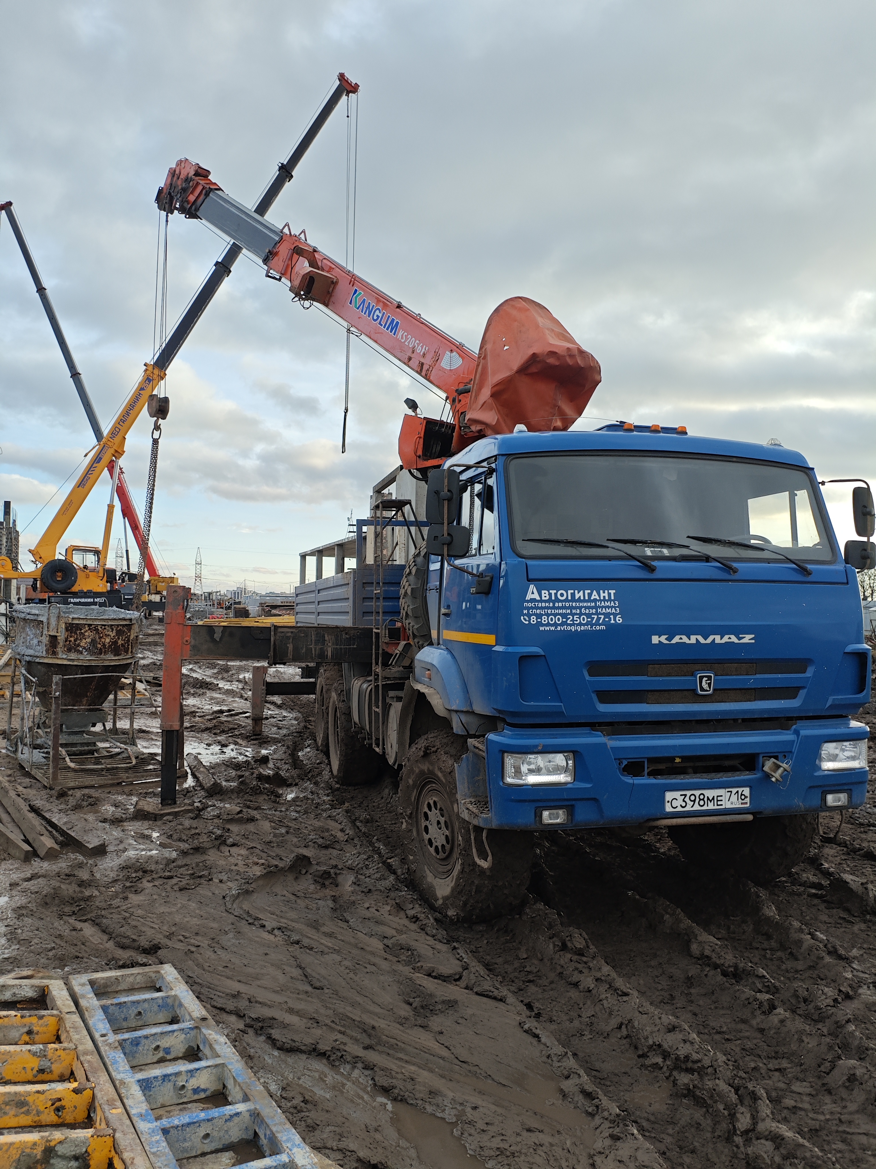 Кран-манипулятор Kanglim на шасси КАМАЗ 6×6 разгружает груз на стройке