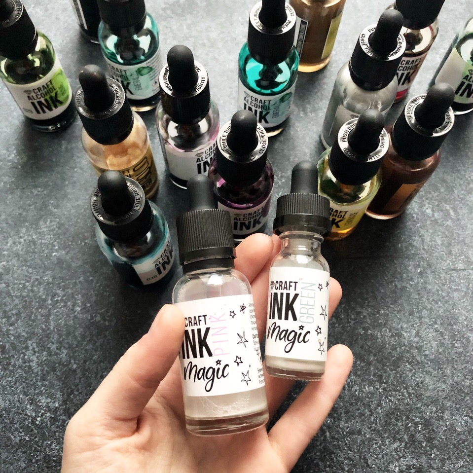 Руки держат два флакона CRAFT INK Magic на фоне набора чернил