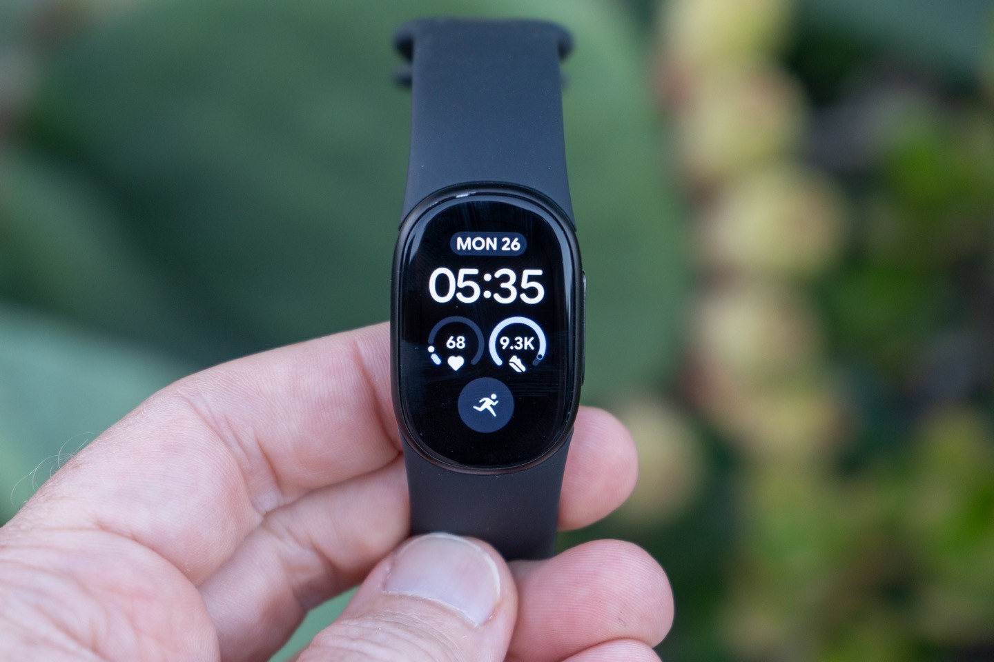 Fitbit Edge в руке с циферблатом на экране Fitbit Edge в руке с циферблатом на экране