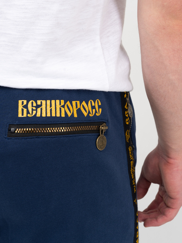 Спортивные штаны цвета синего денима с манжетами, с лампасами. Плотный футер