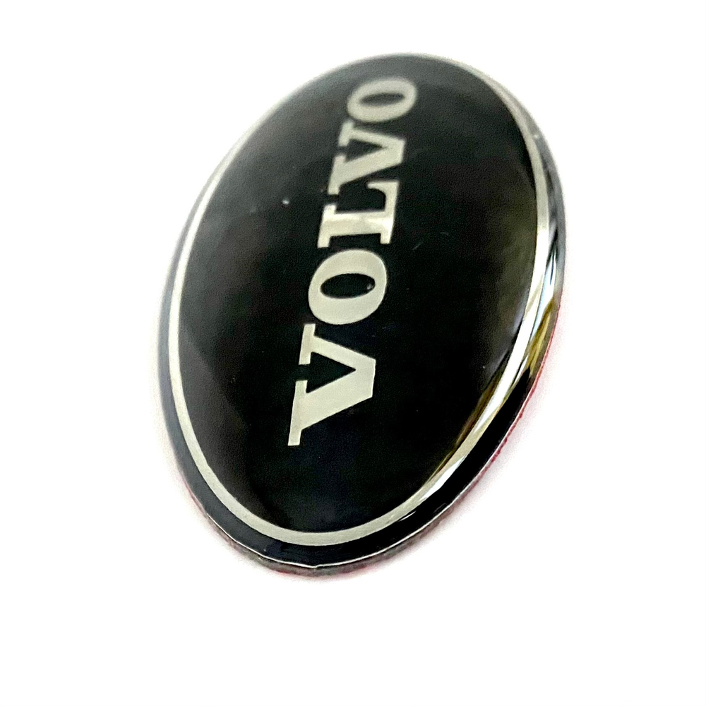 Наклейка Volvo овальная объемная (шильдик Вольво, 6,4х3,5см). Черная с серебристой надписью