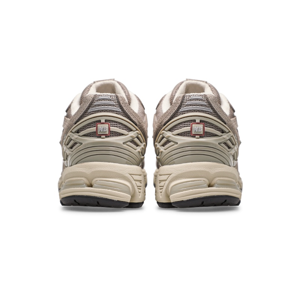 alt="Серый логотип N на боковой стороне New Balance 1906R Beige Cream"