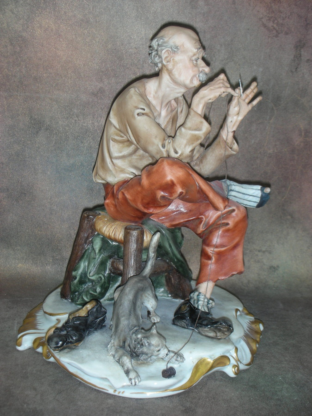 Статуэтка. Фарфор. Мужчина, зашивающий носок. Capodimonte. Италия