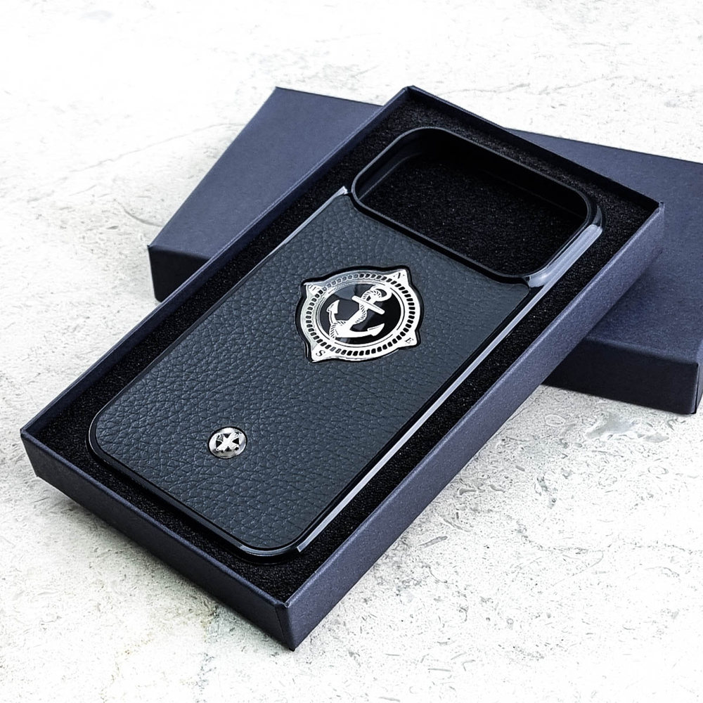 Чехол iPhone 18 Pro Max Euphoria HM Premium Mariner Black Leather в открытой тёмно-синей фирменной подарочной коробке с чёрной поролоновой вставкой — серебряный металлический Адмиралтейский якорь в шестиугольном медальоне с канатным ободом буквы N E S W компас ювелирный сплав чёрная зернистая кожа теленка Италия круглый шильд Euphoria светлый мрамор