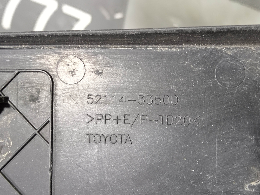 Накладка переднего бампера Площадка гос. номера Toyota Camry (XV70) 20-нв Б/У Оригинал 5211433500