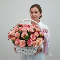 Композиция из 35 роз в белой плетеной корзине в руках у девушки.