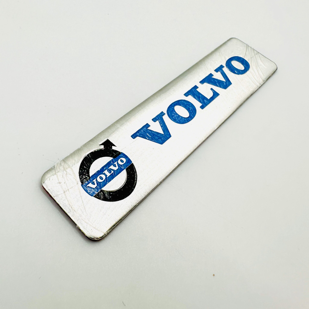 Наклейка Volvo с лого объемная полиурентан (шильдик Вольво, 12х2,5см). Серебристая с синей надписью и лого