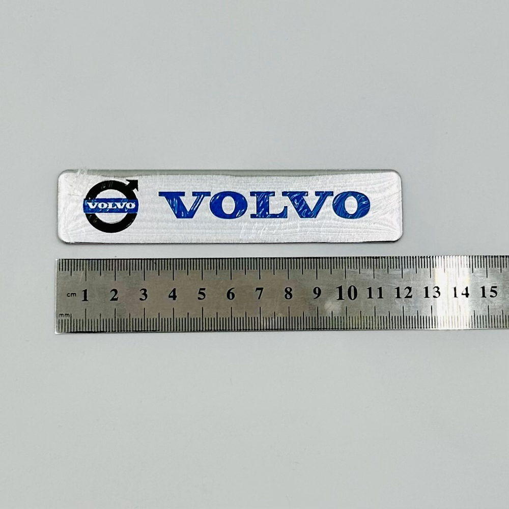 Наклейка Volvo с лого объемная полиурентан (шильдик Вольво, 12х2,5см). Серебристая с синей надписью и лого