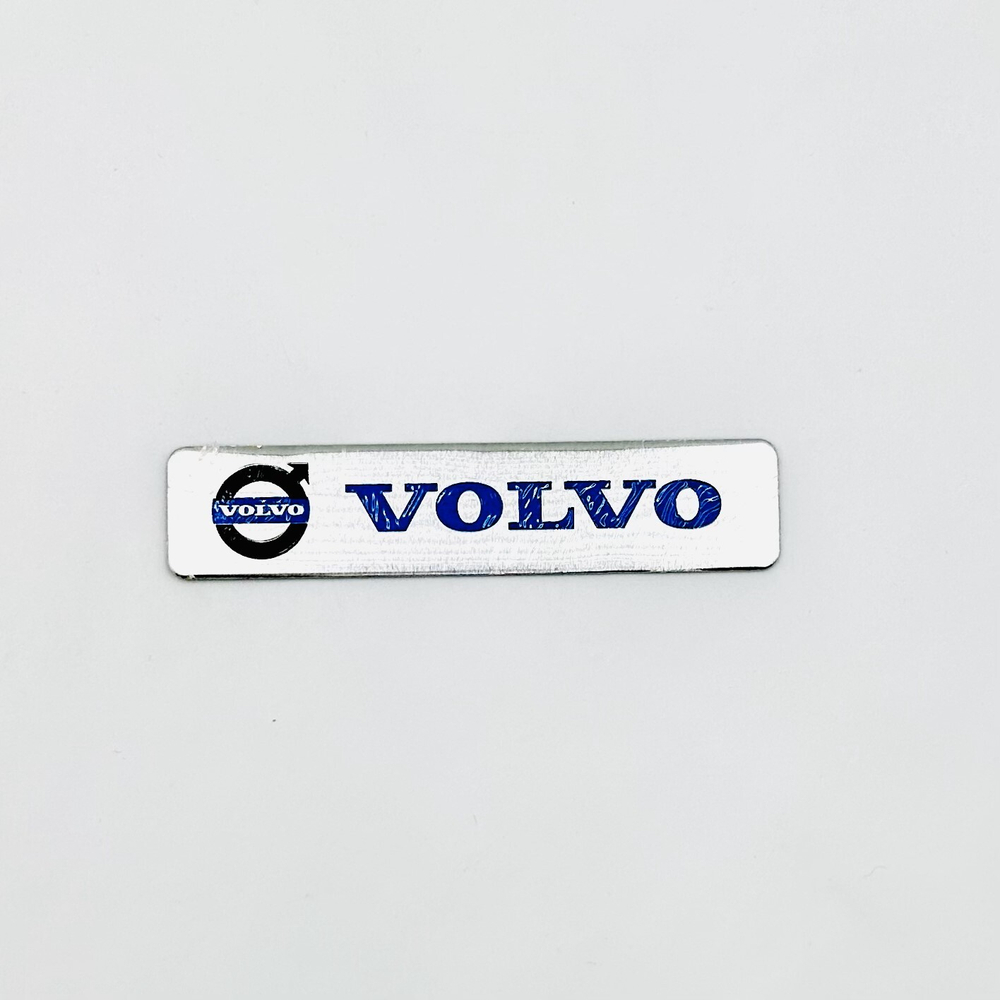 Наклейка Volvo с лого объемная полиурентан (шильдик Вольво, 12х2,5см). Серебристая с синей надписью и лого