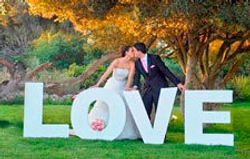 Влюблённые рядом с огромной надписью LOVE из пенопласта.