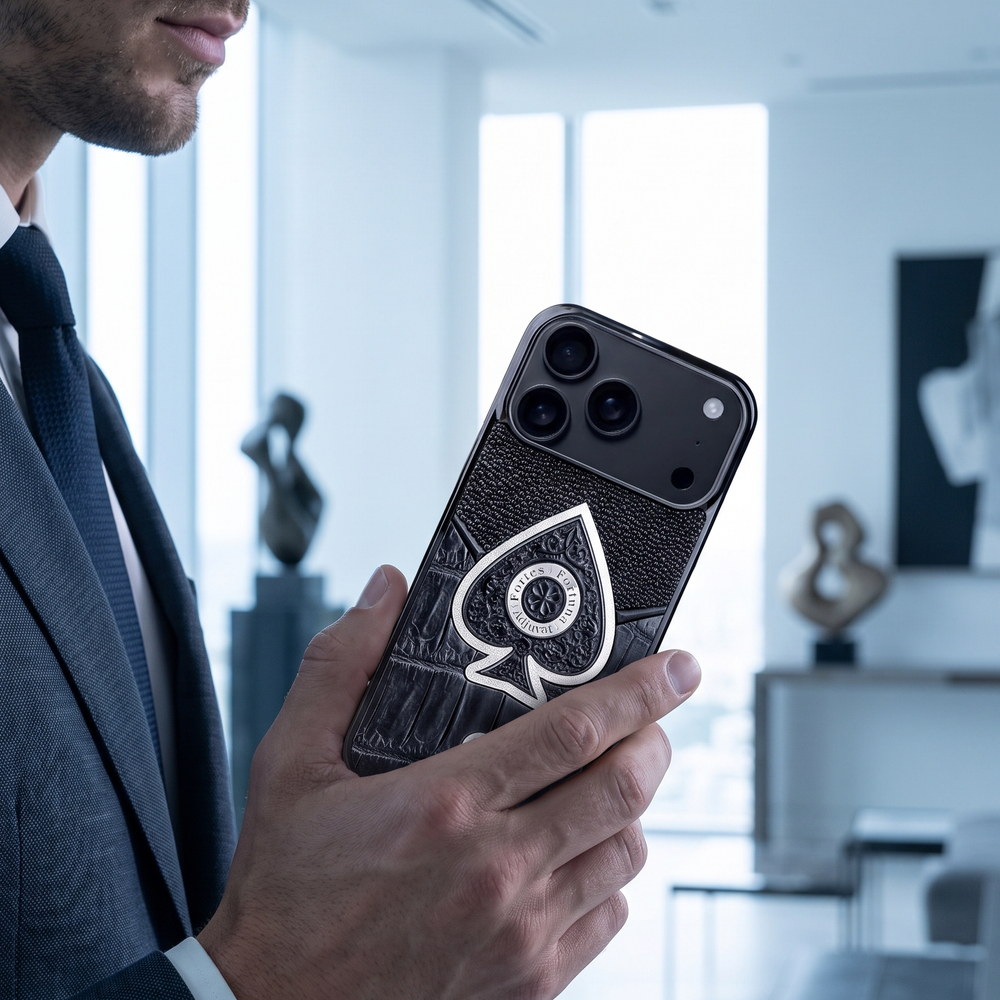 Мужчина в деловом костюме держит iPhone 18 Pro в чехле Euphoria Ace of Spades LUX — кожа крокодила и ската, серебряная ювелирная вставка туз пик, офис с панорамными окнами, премиальный кожаный чехол iPhone 18 Pro Max для делового человека, ручная работа Euphoria HM